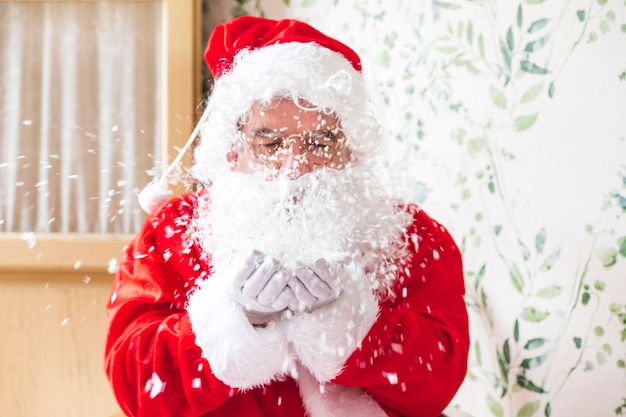 Free photo santa claus blowing snow