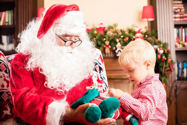 Санта-Клаус дает подарок ребенку: