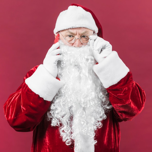 Санта-Клаус в очках разговаривает по телефону