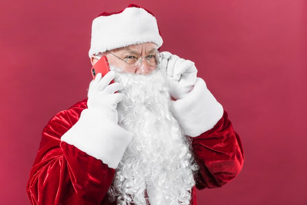 Санта-Клаус в шляпе разговаривает по телефону