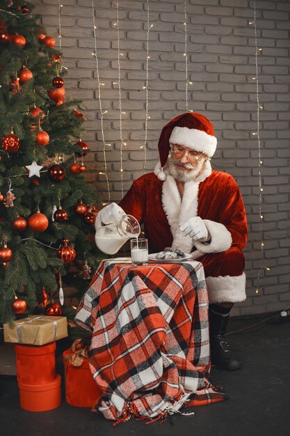 Дед Мороз отдыхает у новогодней елки. Украшение дома. Подарок Деду Морозу.