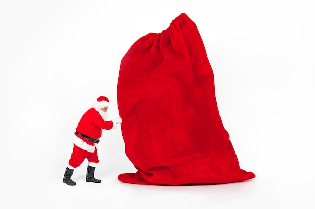 Free photo santa claus holding giant christmas bag