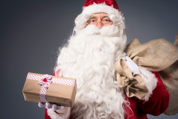 Санта-Клаус держит подарочную коробку
