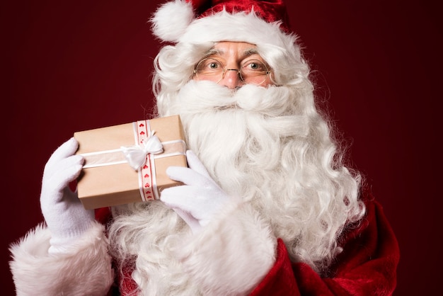 Санта-Клаус держит подарочную коробку