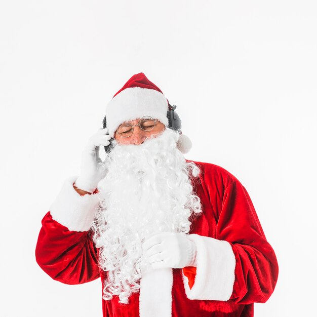 Santa Claus listening to music with headphones 