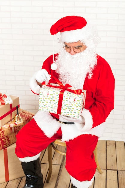 Free photo santa claus opening christmas gift