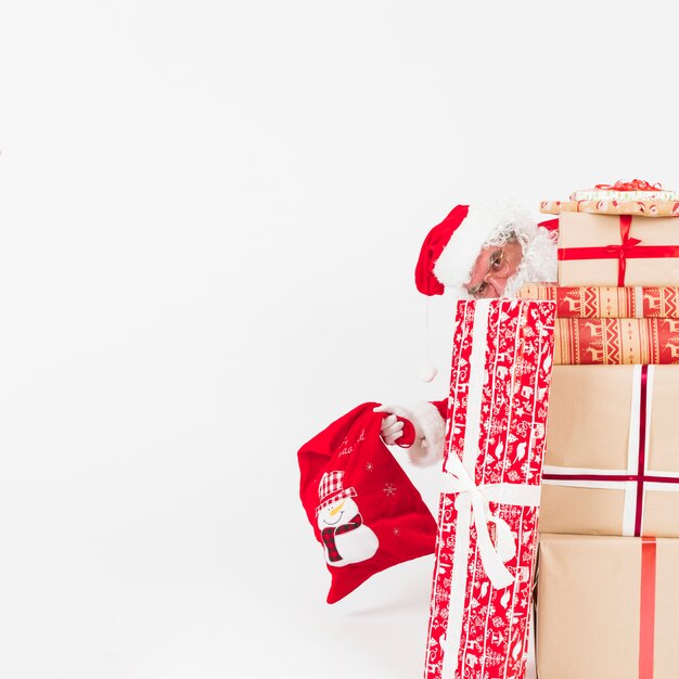 Santa Claus peeking out of gifts boxes