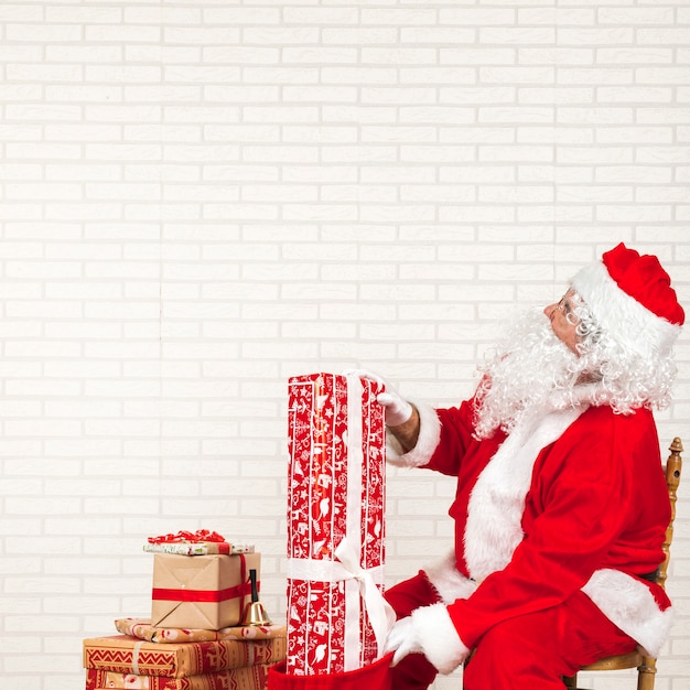 Санта-Клаус ставит подарки в сумке