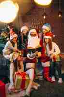 Free photo santa claus reading a book to a group of kids