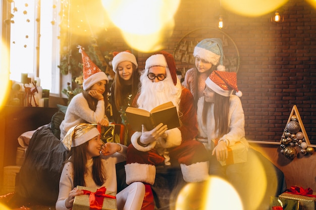 Санта-Клаус читает книгу группе детей