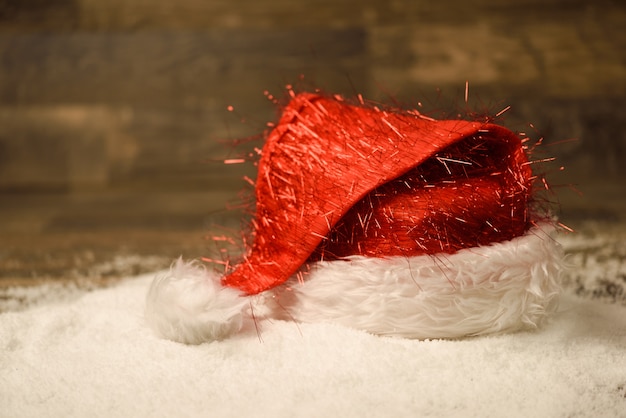 雪の床の上にサンタクロースの赤い帽子