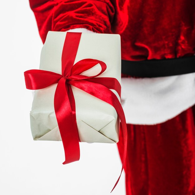 Santa Claus in red holding small gift box