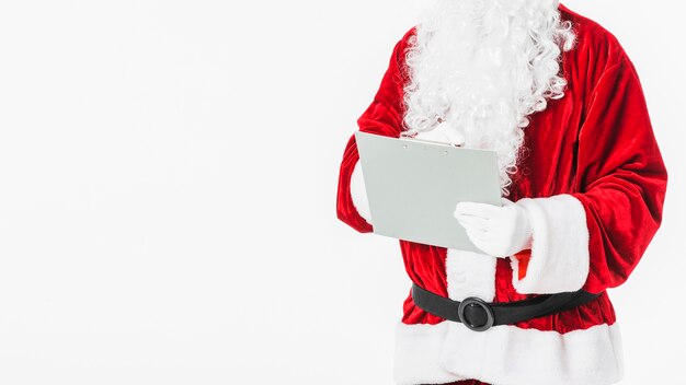 Санта-Клаус в красном письме на бумаге с карандашом