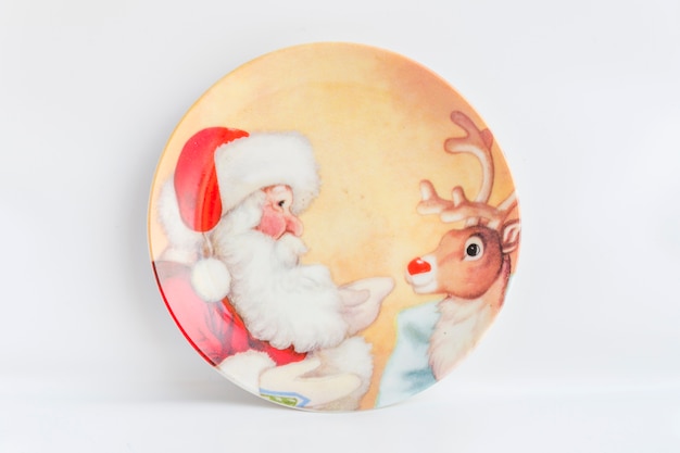 Free photo santa claus and reindeer painted plate on white background