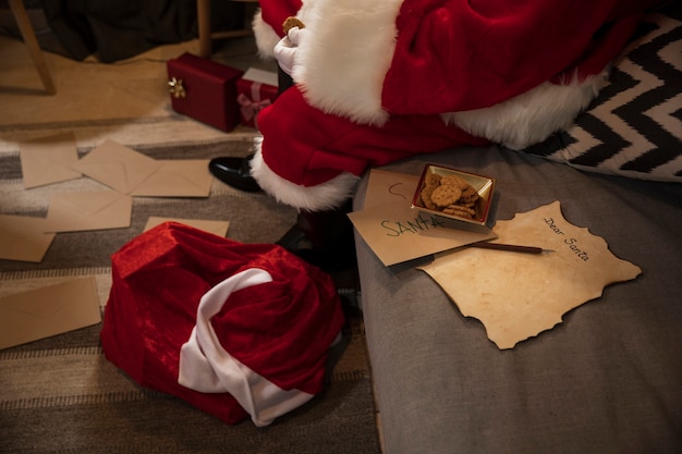 Free photo santa claus sitting next to his list