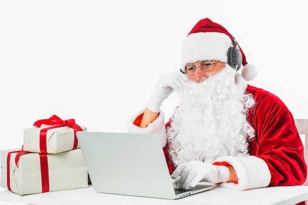 Santa Claus at table using laptop 