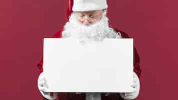 Free photo santa claus with blank white paper in hands