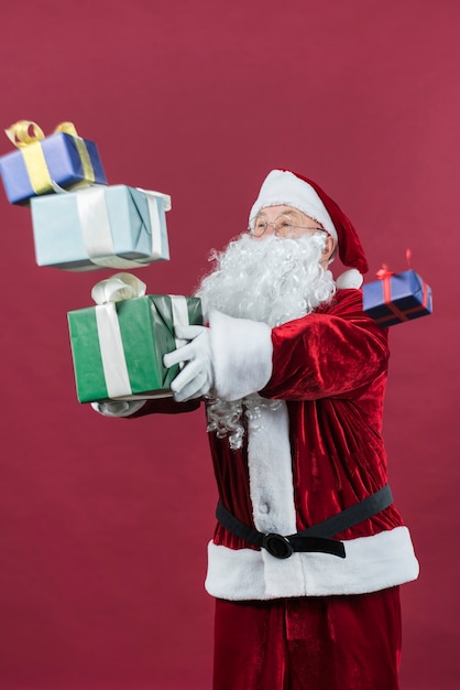 Free photo santa claus with colourful gift boxes in hands