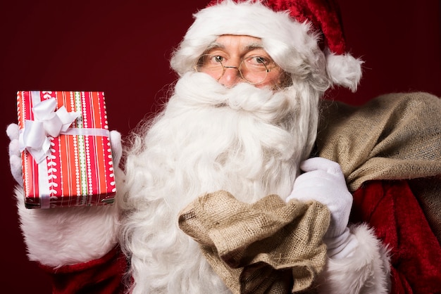 Santa Claus with a gift box on red background