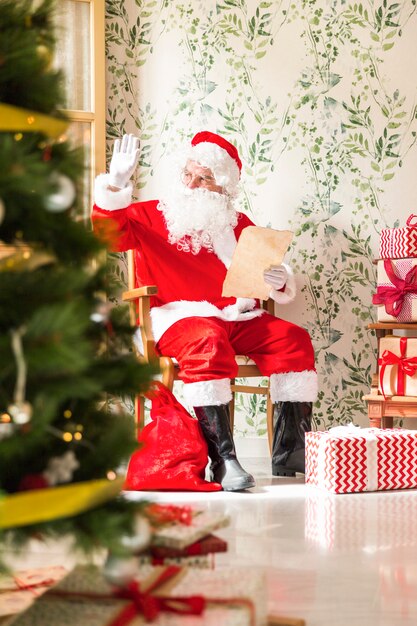 Santa Claus with letter sitting on chair