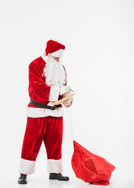 Santa Claus with sack of gifts and children list