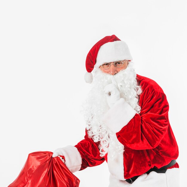 Santa Claus with sack showing secret gesture