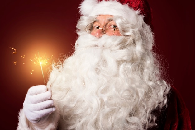 Santa Claus with a sparkler on red background