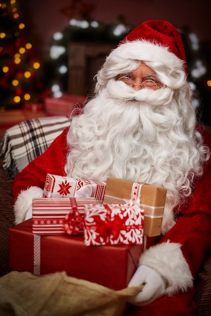 Santa Claus with stack of christmas presents