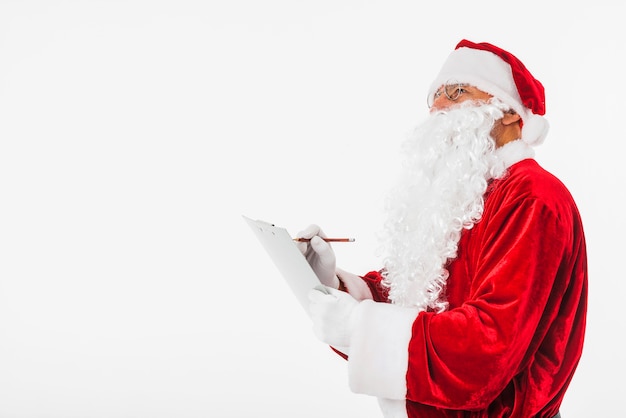 Santa Claus writing on clipboard 