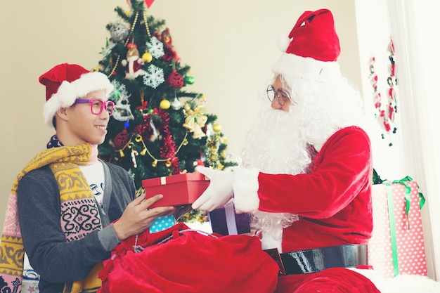 Санта-Клаус и мальчик с подарочными коробками