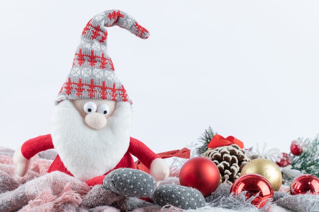 Free photo santa figurine and festive baubles on white surface