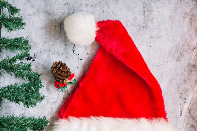 Santa hat with fir tree branches on table