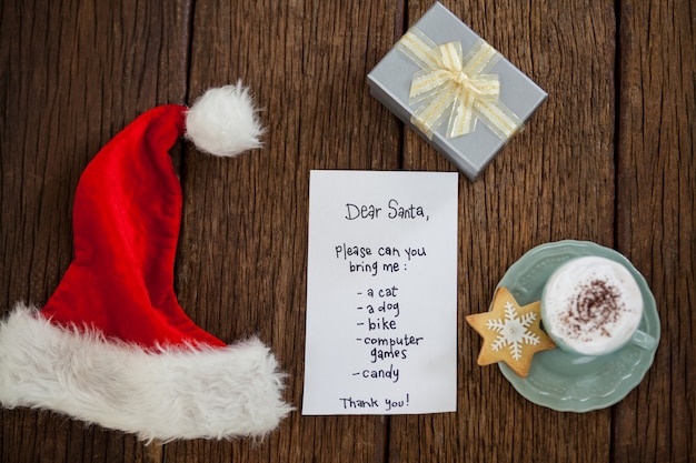 Foto gratuita cappello di babbo natale con una lettera e una tazza