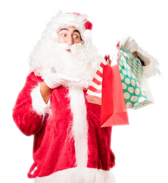 Free photo santa pointing shopping bags of colors