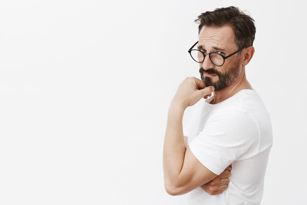 Sassy handsome bearded mature man with glasses posing