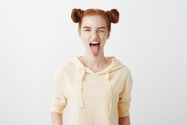Free photo sassy redhead girl wink and showing tongue happy