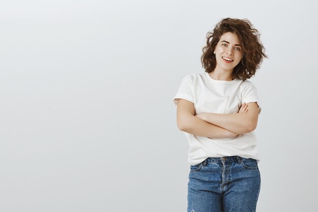 Sassy stylish girl with curly hair cross arms chest and smiling