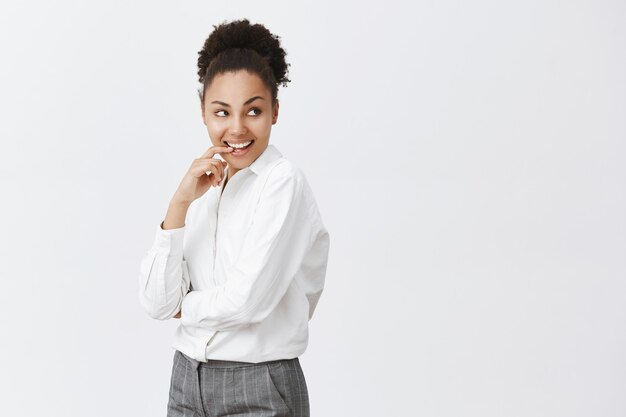 Sassy and thoughtful african american woman smiling pleased, pondering great business idea, looking right