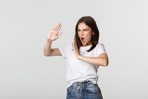 Sassy young woman standing in fighting pose to protect herself from attack.