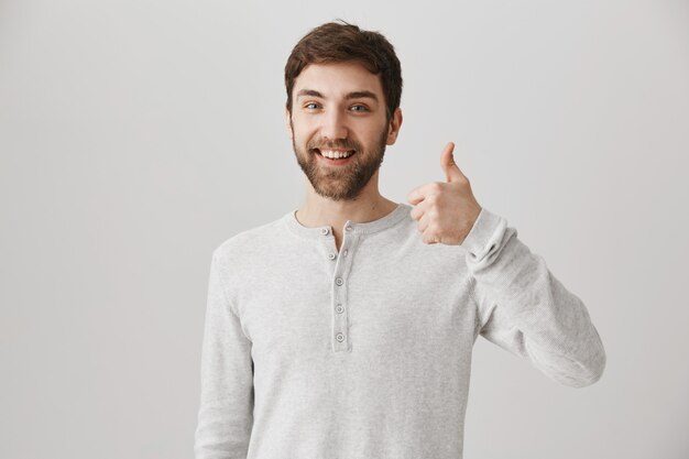 Satisfied bearded male customer show thumbs-up in approval