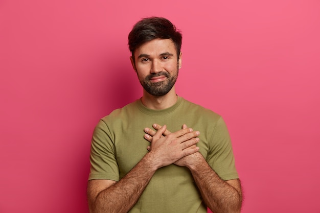 Free photo satisfied bearded smiling man makes gratitude gesture