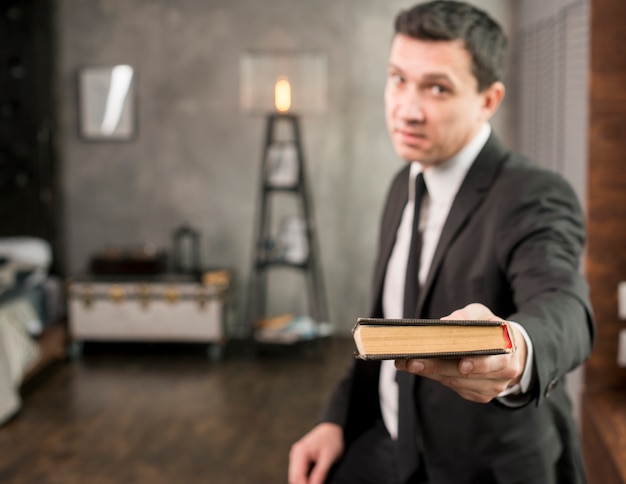 Satisfied businessman offering book