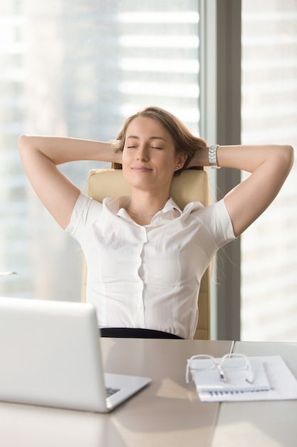 Free photo satisfied businesswoman leaning back in chair