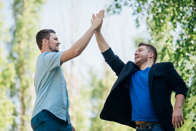 Free photo satisfied friends giving high five