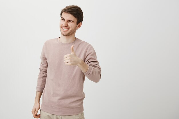 Satisfied handsome caucasian man showing thumbs-up