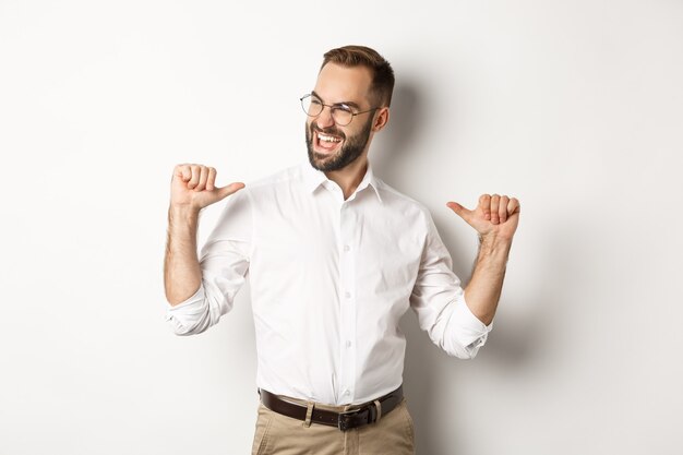 Satisfied and self-assured businessman pointing at himself, standing  