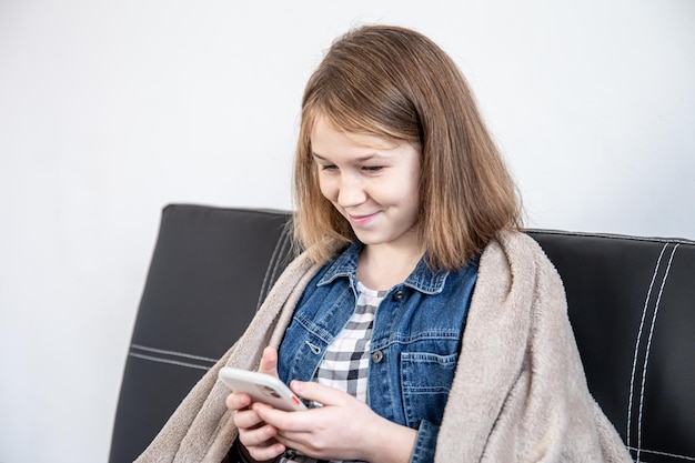 満足している10代の少女がスマートフォンの画面を見る