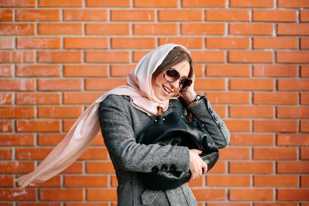 Satisfied young lady holding her handbag