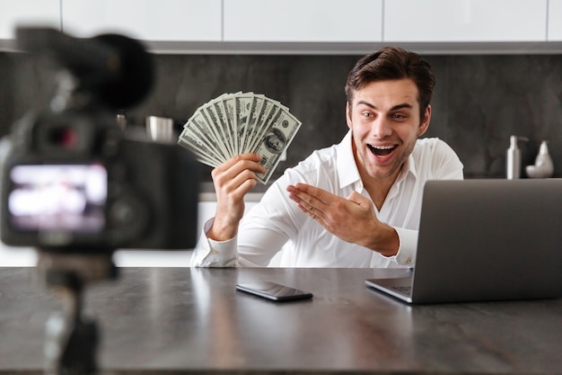 Free photo satisfied young man filming his video blog episode