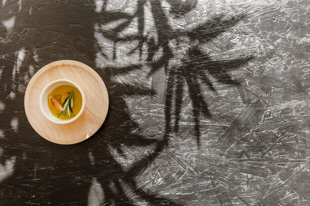 Sauceboat with oil on wooden stand on table